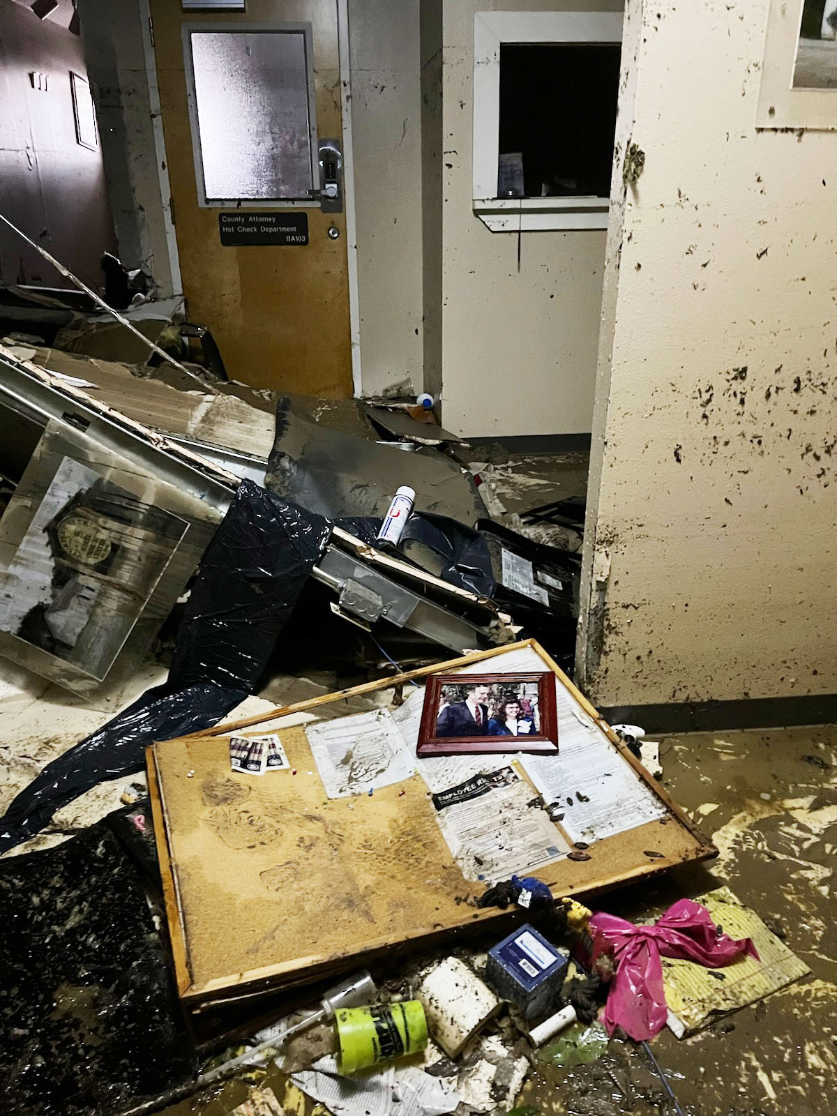 An interior hallway shows a pile of rubble left after water was pumped out of the basement of the Kerr County Courthouse.